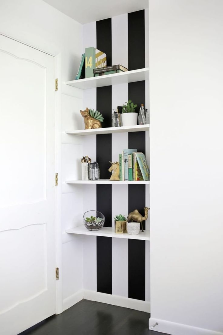 a black and white striped wallpapered room with bookshelves on the shelves