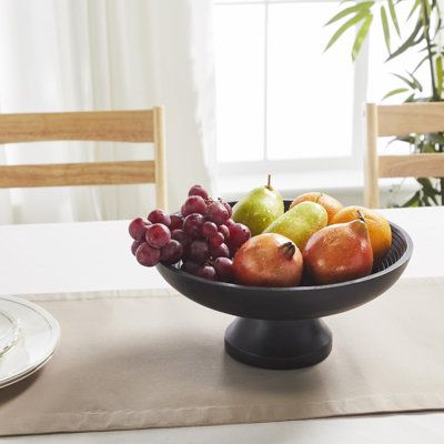 a bowl filled with fruit sitting on top of a table