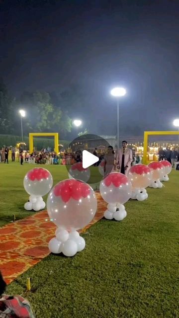 balloons are lined up on the grass at night