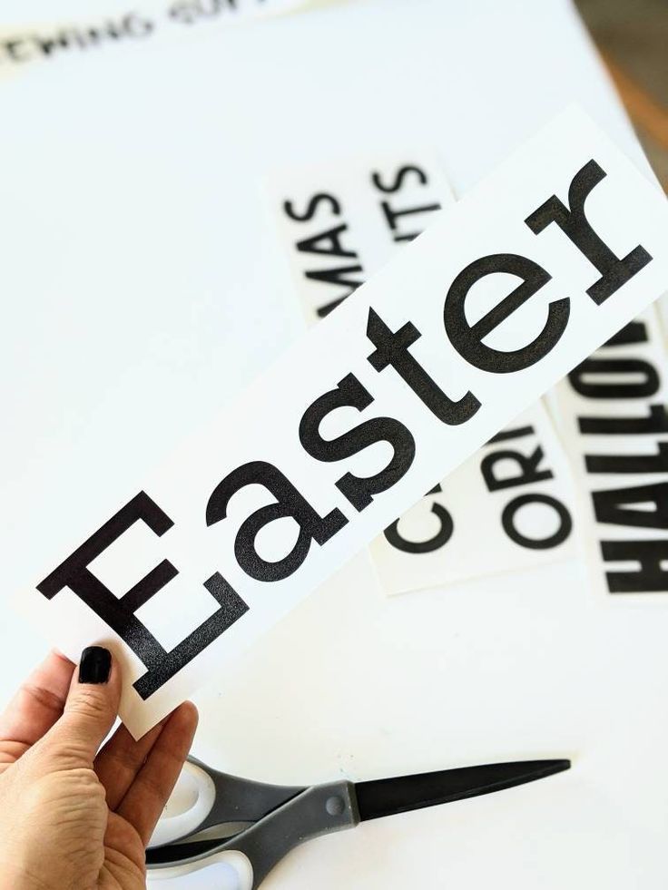 a pair of scissors that are on top of a piece of paper with the word easter cut out