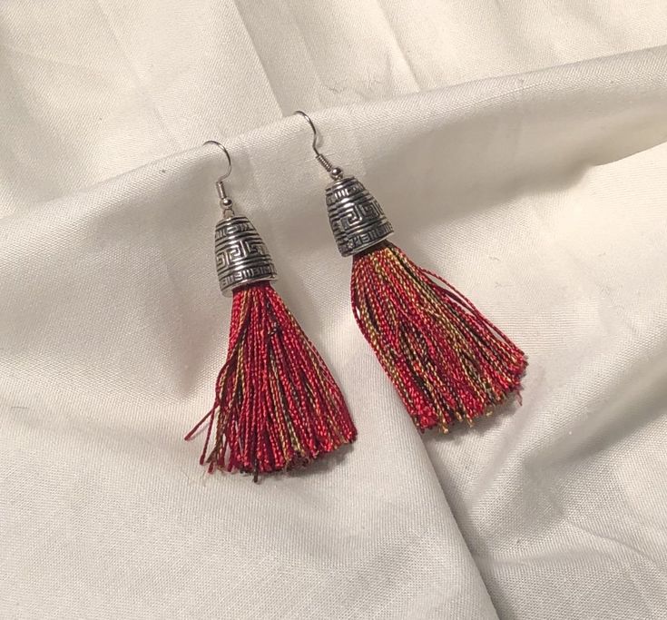 Stylish and festive red tassel earring.  Fun to wear and great with any look. Measures 3 inches end end. Red Dangle Tassel Earrings With Latkans, Red Tassel Earrings With Latkans For Gifts, Red Tassel Earrings With Latkans As Gift, Red Latkans Tassel Earrings For Gifts, Red Dangle Tassel Earrings With Fringe, Red Tassel Beaded Earrings, Red Beaded Tassel Earrings, Festive Dangle Tassel Earrings, Traditional Tassel Drop Earrings For Party