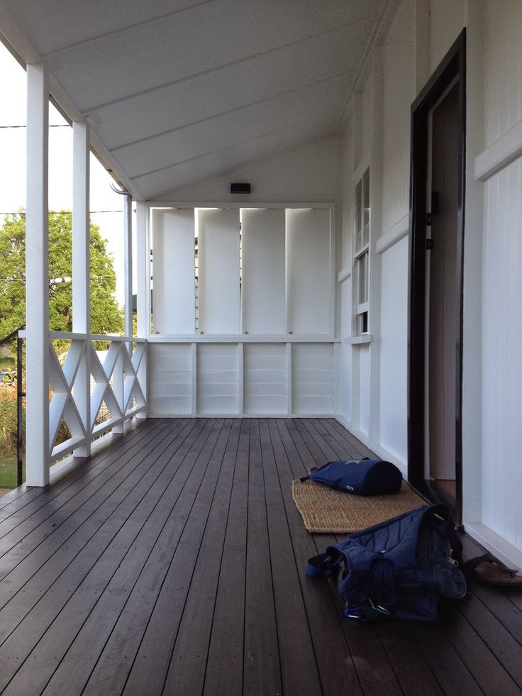 an empty porch with white walls and wooden floors