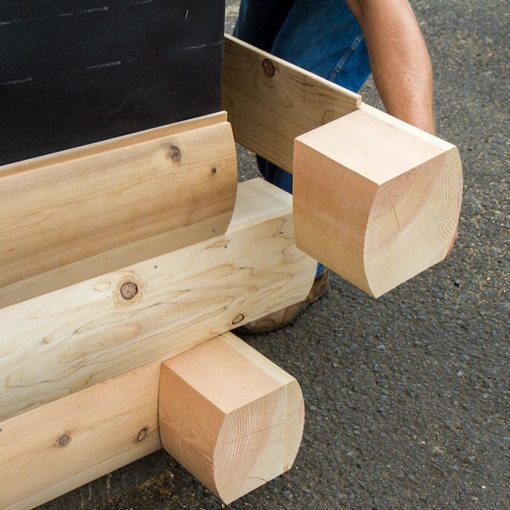 a person sitting on the ground next to some wood