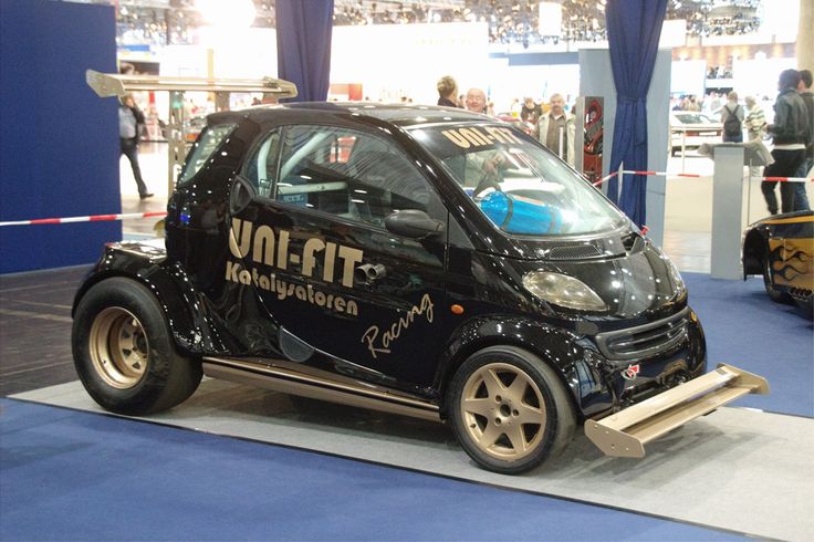 a small car with wheels on display at an auto show