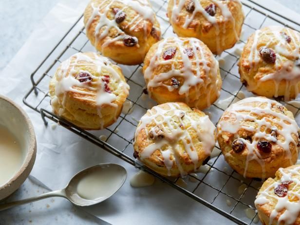 a wire rack filled with muffins next to a cup of milk and spoon