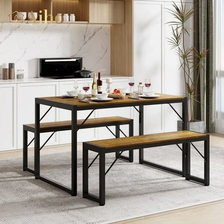 a kitchen table with two benches in front of it and a microwave on the wall