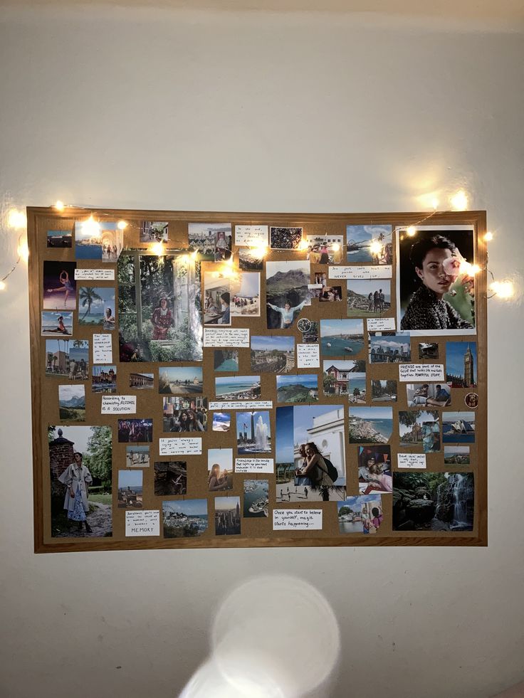 a bulletin board with pictures and lights on the wall in a room that is decorated with string lights