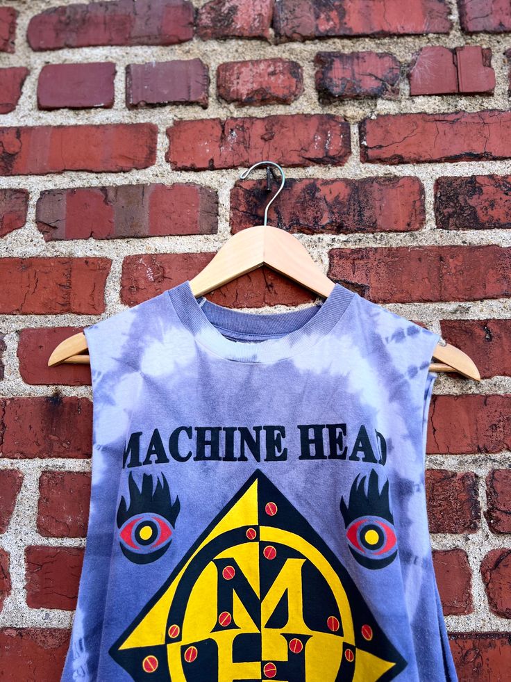 Description: Show off your vintage style with our 1994 Vintage Machine Head Burn My Eyes Tank! Made from high-quality materials, this tank features a cool and attractive graphic that will make you stand out. Perfect for music fans and fashion enthusiasts alike. Available in size XL. Material: 100% Cotton Size: XL Length: 28.5” Chest: 46” Label: unbranded sold as is for sleeves cut Condition: This item is pre-loved Casual Cotton Vest For Concert, Acid Wash Cotton Tank Top For Festivals, Fitted Vest With Graphic Print And Crew Neck, Cotton Grunge Vest For Concerts, Acid Wash Graphic Print Muscle Tee With Crew Neck, Summer Screen Print Muscle Tee For Streetwear, Punk Style Cotton Tank Top For Concerts, Acid Wash Band Merch Tops For Music Festival, Retro Muscle Tee With Graphic Print For Summer