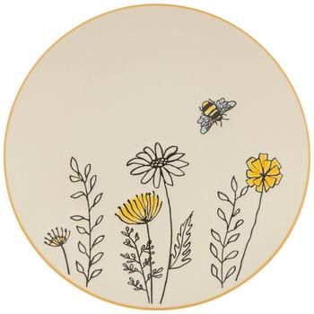 a white plate with yellow flowers and a bee on the side, in front of a white background