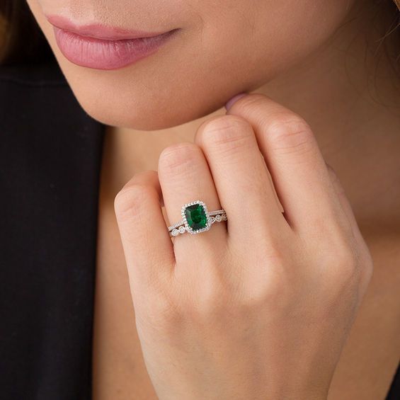 An eye-catching style, this vintage-inspired bridal set matches your bold romance. Crafted in sterling silver, the colorful engagement ring showcases an 8.0 x 6.0mm cushion-cut lab-created verdant-green emerald wrapped in a frame of shimmering petite diamonds - all set atop a glimmering diamond-lined shank. On your wedding day, complete her look with the coordinating band that features a row of alternating marquise-shaped and round frames adorned with sparkling petite diamonds and intricate milg Timeless Wedding Jewelry With Center Stone, Formal Emerald Cut Diamond Bridal Sets, Platinum Jewelry With Green Diamond Accents, Elegant Green Platinum Jewelry, Classic Bridal Set With Halo Setting For Anniversary, Elegant Emerald Cut Bridal Sets, Silver Princess Cut Emerald Ring For Wedding, Sterling Silver Cushion Cut Wedding Rings, Wedding Emerald Gemstone Ring In Platinum