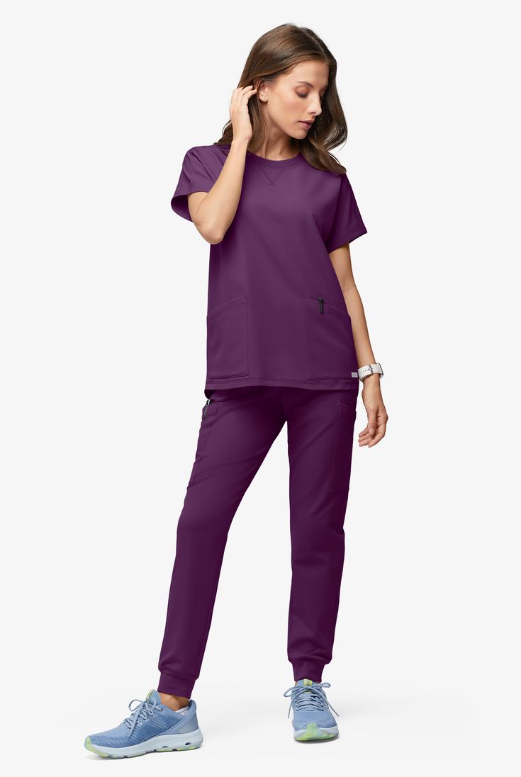 Oversized tops are definitely having a moment. This one’s cute and practical, with dolman sleeves, a high-low hem and four handy pockets. Every style in our ReSurge collection is an earth-loving gem. Made of 95% recycled polyester (the most of any scrubs brand!), plus recycled trims, elastics, zippers. Even the bag it comes in is recycled. Long story short: ReSurge lets you feel good and do good. • Recycled fiber from approximately 14 plastic bottles • Slightly oversized fit • Rib-trim crewneck Oversized Purple Workwear Tops, Oversized Purple Tops For Work, Purple Short Sleeve Tops With Pockets, Versatile Relaxed Fit Tops With Side Pockets, Solid Tops With Side Pockets For Loungewear, Versatile Relaxed Fit Tops With Pockets, Versatile Tops With Pockets And Relaxed Fit, Loungewear Tops With Side Pockets, Solid Color Tops With Pockets And Shirttail Hem