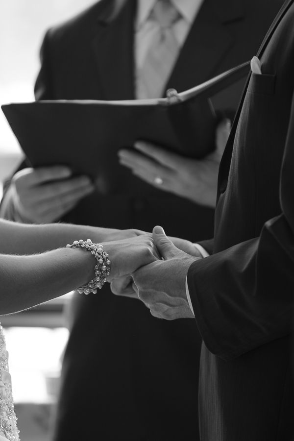 the bride and groom hold hands during their wedding ceremony