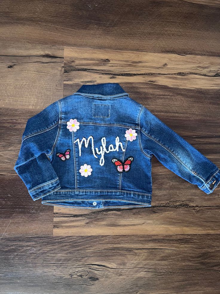 Custom upcycled denim jacket. Hand embroidered by me! Can be customized in any embroidery color and different patches added at request!  Washes can vary depending on availability, please specify if you have a preference on the wash. Due to this being a one of a kind custom made order, I will not accept returns. Spring Embroidered Patch Denim Jacket, Spring Cotton Denim Jacket With Embroidered Patch, Long Sleeve Denim Jacket With Patches, Spring Denim Jacket With Embroidered Patch, Blue Embroidered Cotton Denim Jacket, Casual Blue Denim Jacket With Custom Embroidery, Spring Cotton Outerwear With Embroidered Patch, Spring Denim Outerwear With Custom Embroidery, Medium Wash Cotton Denim Jacket With Floral Embroidery