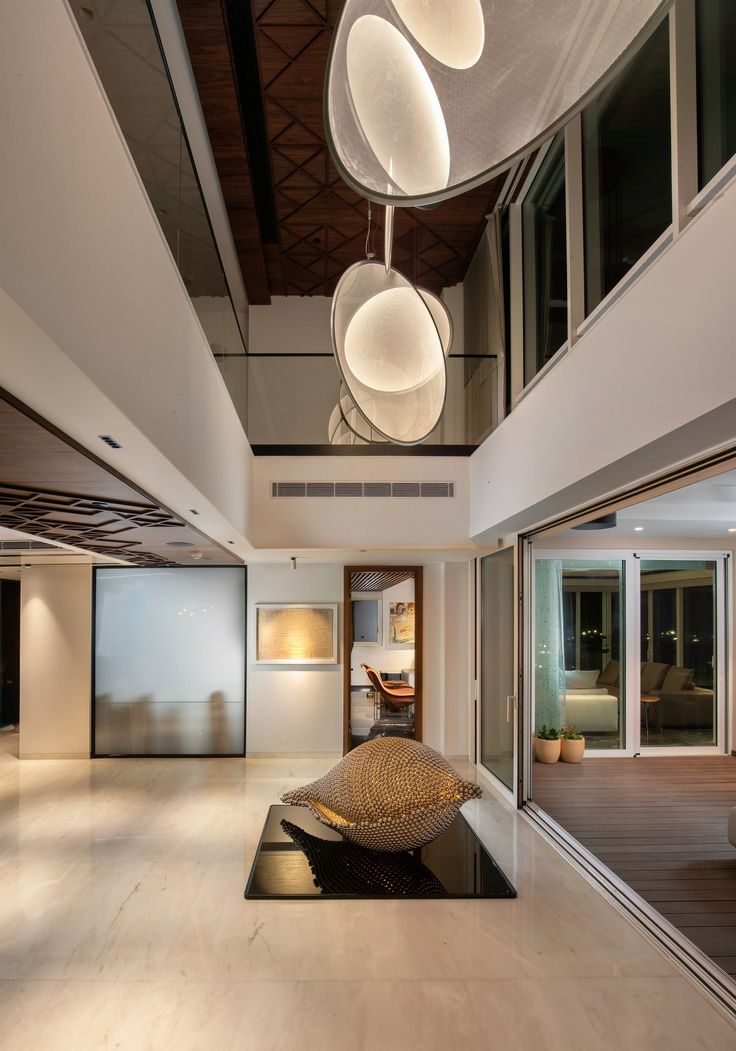 an empty room with modern lighting fixtures hanging from the ceiling