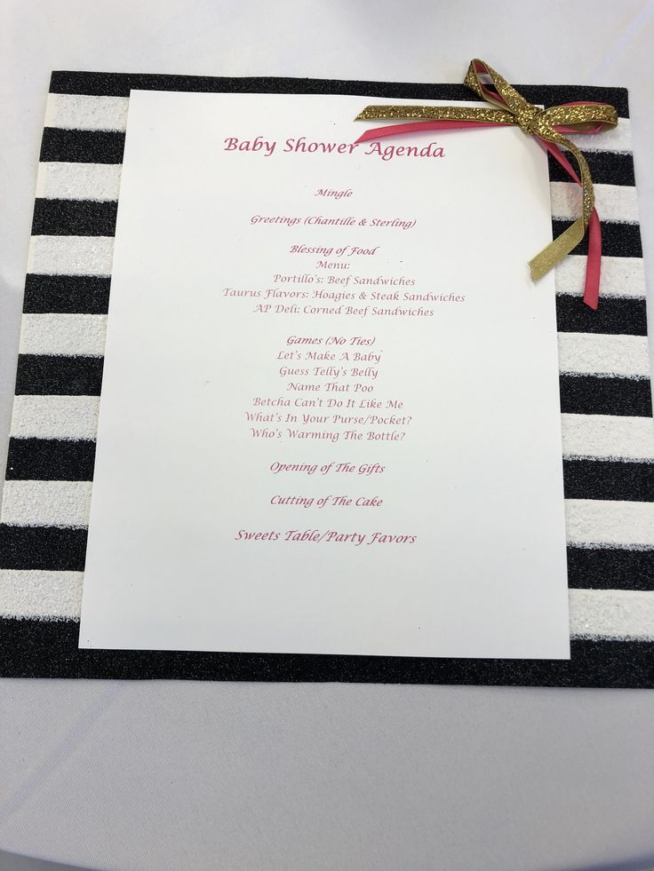 a baby shower agenda with a ribbon on it's back and black and white stripes