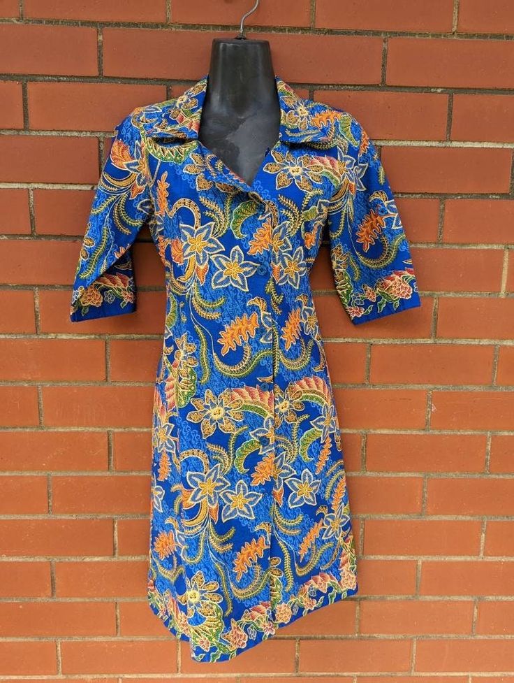 Found! 🔍 Super cool shirt-dress with asymmetrical button line and ability to be buttoned high necked or folded open. We especially love the cobalt blue colour contrasted with the orange tropical paisley floral swirling all over. 📋 - This dress is in excellent vintage condition with no noticeable defects. Made by M3rlin.  Size S.  👗 Measurements (taken flat):  - 93cm length  - 40cm shoulder  - 44cm bust  - 38.5cm waist  - 35.5cm sleeve length  - 15cm cuff width ------------------------------ Blue Short Sleeve Formal Shirt Dress, Blue Formal Short Sleeve Shirt Dress, Blue Formal Shirt Dress With Short Sleeves, Formal Blue Short Sleeve Shirt Dress, Blue Cotton Formal Dress, Formal Blue Cotton Dress, Fitted Blue Shirt Dress With Button Closure, Blue Short Sleeve Shirt Dress For Daywear, Blue Cotton Shirt Dress With Buttons