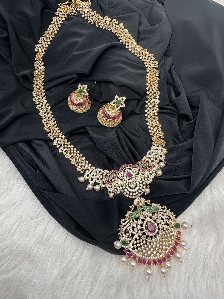 AD Red Green Multi Stone Peacock Pendent Golden Finish Long Necklace comes with Jhumkis Party wear golden finish American diamonds multi Color Necklace Pair it up with Saree Lehenga aur any Party wear dress. Necklace Length : Approx. 22 inches; Comes with adjustable back chain. Earring Length : .2 Inches Screw Back Ready to ship from Massachusetts, USA If you have any questions, Please let me know. Thank you!! Temple Jewelry With Zari Work For Party, Bollywood Style Necklace For Navratri Party, Festive Kundan Necklace With Zari Work For Parties, Gold Kundan Necklace For Navratri Party, Bollywood Party Necklace With Zari Work, Peacock Design Jhumkas For Party And Festivals, Festival Peacock Design Jhumkas For Parties, Bollywood Style Party Necklace With Zari Work, Diwali Party Jewelry With Zari Work