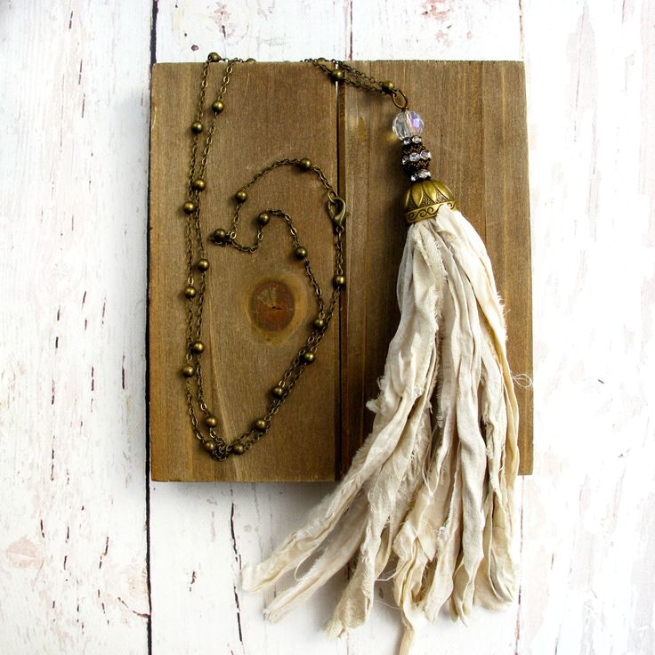 a tasseled book with beads and a necklace on it