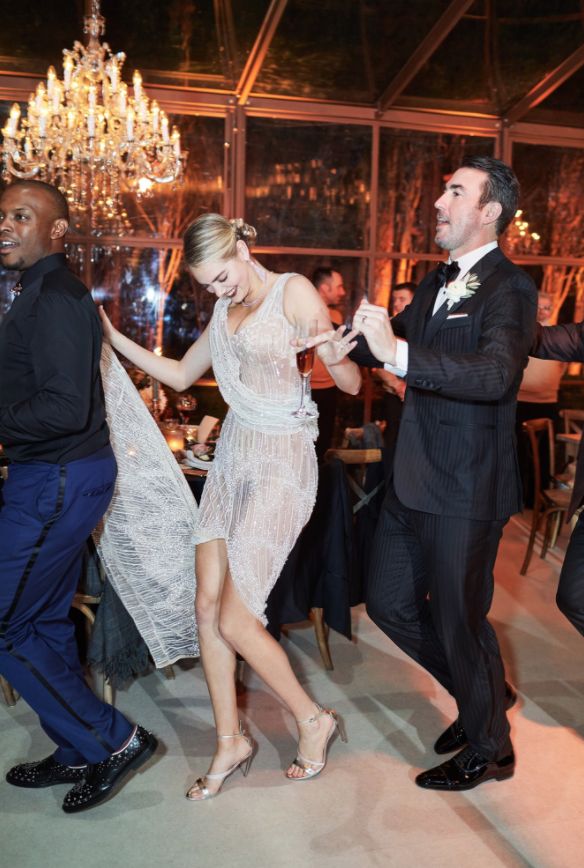 a man and woman dancing at a formal event with chandeliers in the background