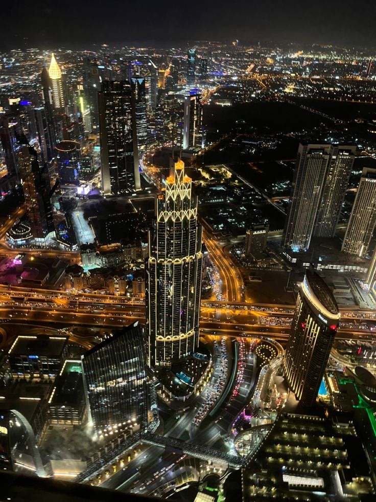 an aerial view of a city at night with lots of lights and buildings in the background