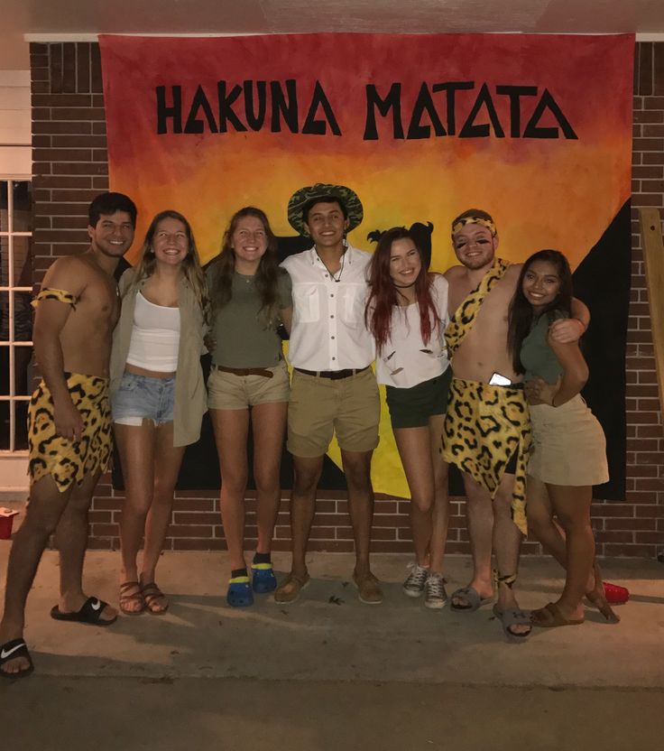 a group of people standing in front of a sign that says hakuna matata