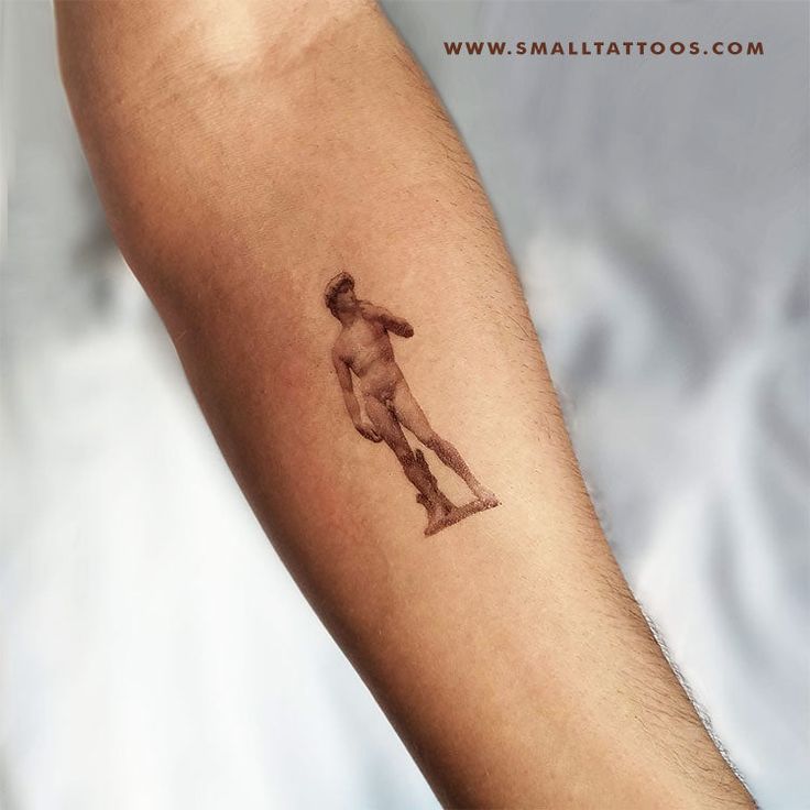 a man's arm with a small tattoo of a baseball player holding a bat