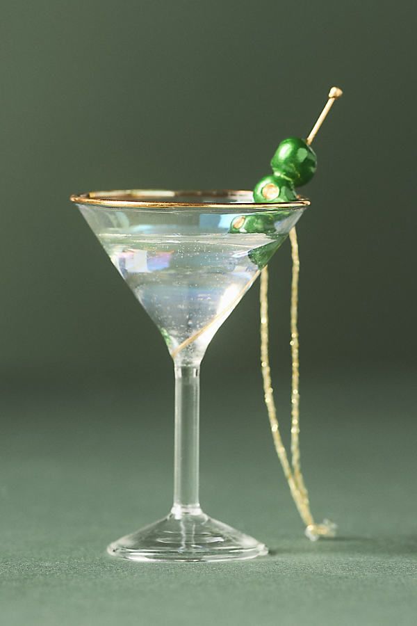 a martini glass with an olive garnish on the rim and a string attached to it