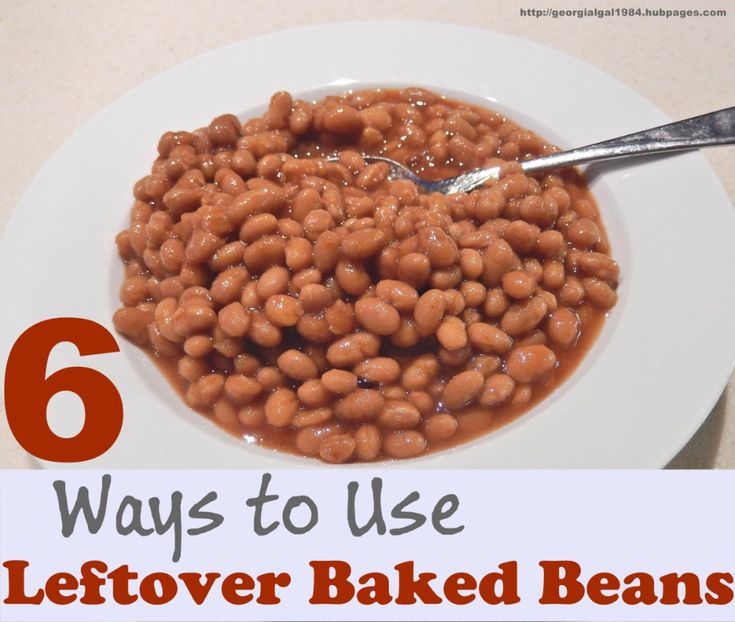 a white plate topped with baked beans on top of a table