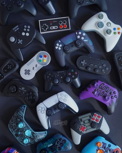 many different video game controllers on a black surface