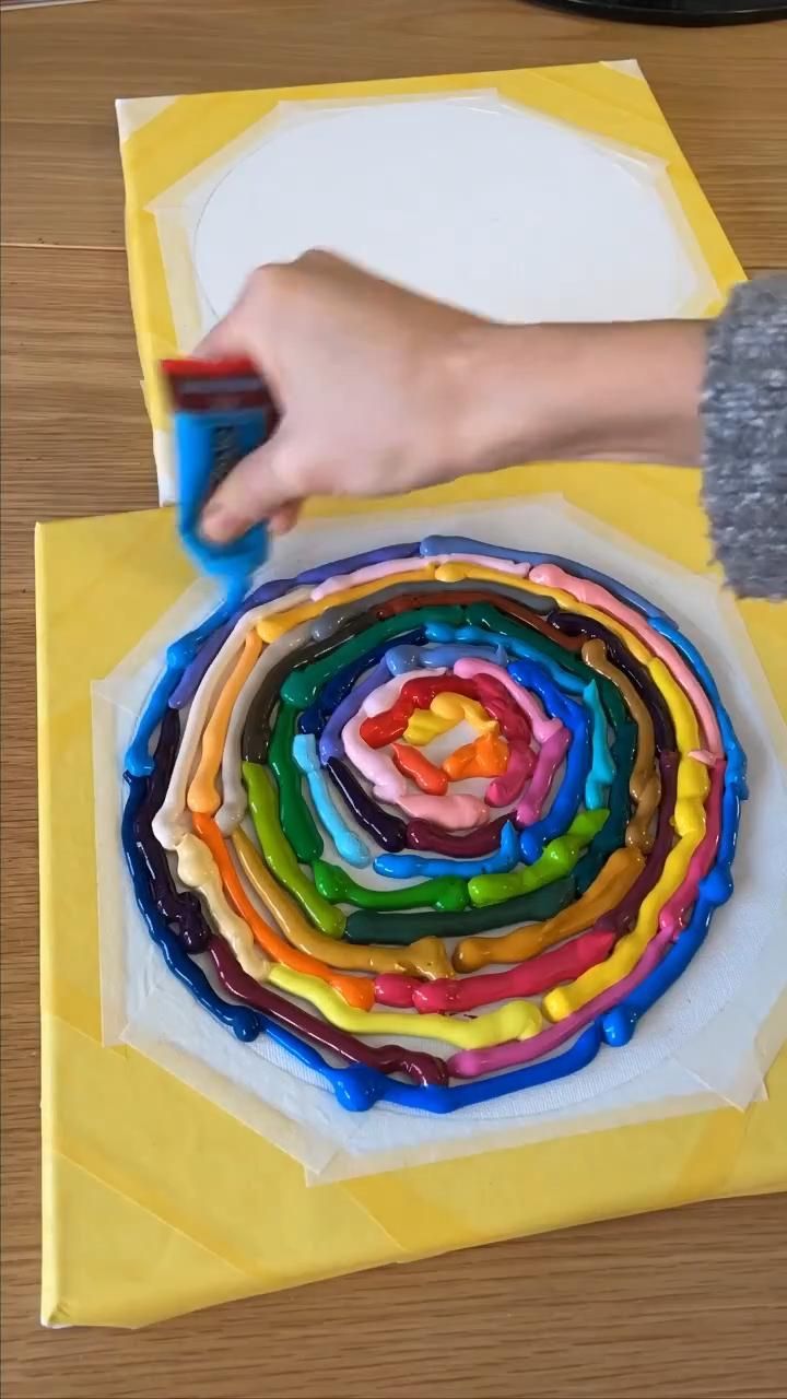 a person is decorating a cake with colorful icing on the top and bottom