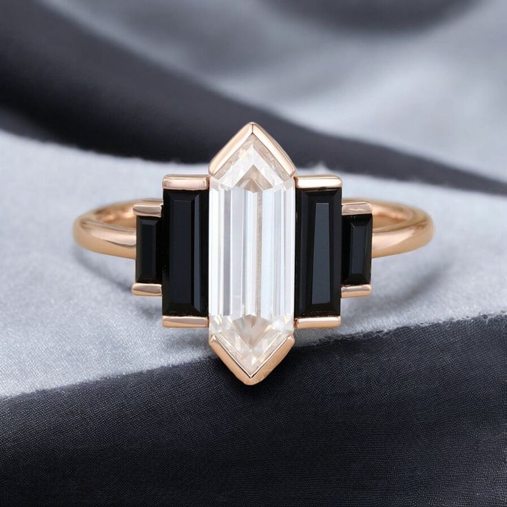 an engagement ring with three black and white stones on the side, set in gold