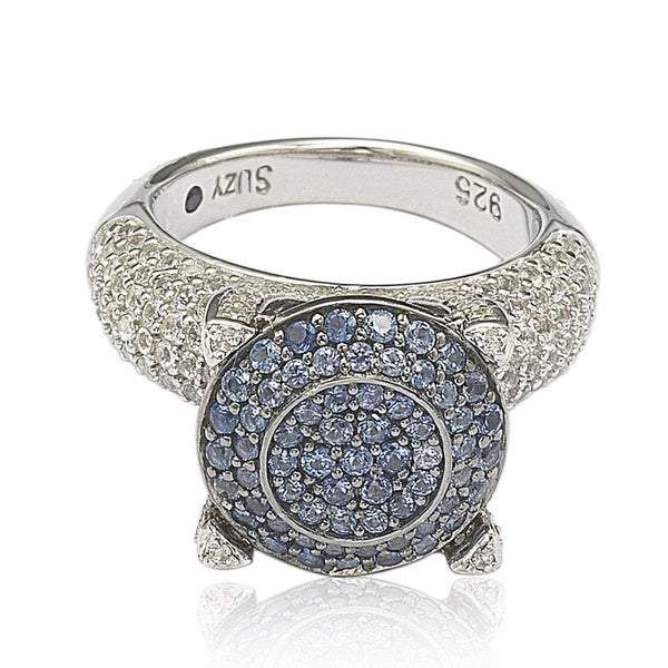 Bedazzling design that beguiles! Crafted in sterling silver, this ring boasts a circle shape at its center covered in fancy color cubic zirconia gemstones. The sides offer a prominent setting accented with sparkling white gemstones than extend in rows down the shank. This gorgeous ring comes in 3 color options: yellow, pink or blue. The Suzy Levian name appears engraved on the inner bottom of the band below the heart shaped cut-out design on the undergallery, giving the piece a finished look. Th Silver Cubic Zirconia Halo Ring With Pave Setting, Sterling Silver Sapphire Ring With Pave Setting, Sapphire Ring With Pave Setting, Round Sapphire Ring With Pave Setting, Round Cubic Zirconia Ring With Pave Setting, Dazzling Sapphire Ring With Pave Setting, Luxury Halo Ring With Cubic Zirconia And Accent Stones, Cubic Zirconia Cluster Ring With Pave Setting, Silver Sapphire Ring With Pave Setting