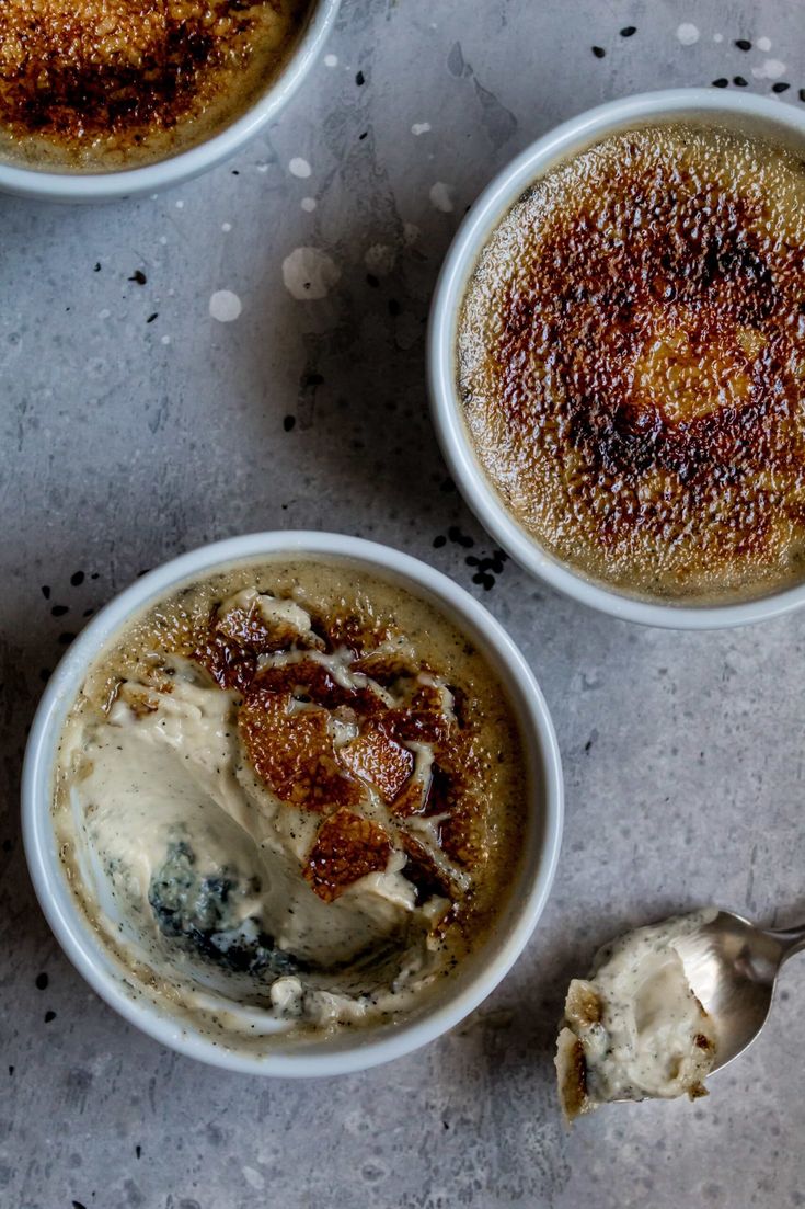 three bowls filled with different types of desserts on top of a table next to a spoon