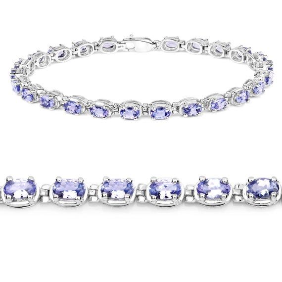 6.25 Carat Genuine Tanzanite .925 Sterling Silver BraceletProduct Details:Metal: .925 Sterling SilverSetting: prongsItem: BraceletFinish: Rhodium PlatedMetal Stamp: 925 QJ™ INTotal CTW: 6.25 CaratLength 7.50 inchesWidth 4.06 MMHeight 4.06 MMWeight: 9.05 GramsChain Type: No Chain TypeClasp Type: Single Strand FishhookGemstone Information:TanzaniteQuantity: 25/6.25 ctw Shape / Size: Oval/5x3mm Oval Sterling Silver Bracelet In Fine Jewelry Style, Fine Jewelry Sterling Silver Oval Bracelet, Classic Sterling Silver Bracelet With Oval Gemstone, Classic Sterling Silver Oval Gemstone Bracelet, Classic Oval Gemstone Sterling Silver Bracelet, Oval Sterling Silver Bracelet, Sterling Silver Oval Jubilee Bracelet, Sterling Silver Oval Jubilee Bracelet In Fine Jewelry Style, Cluster Earrings Studs