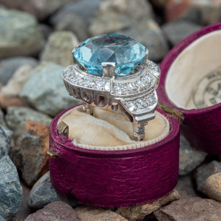 This round aquamarine ring is centered with a round mixed cut aquamarine in a four-prong setting. The top of the ring is accented with milgrain details and is bead set with eighteen (18) round single cut diamonds. The shoulders are each bead set with three (3) round single cut diamonds. The ring measures 20.8mm at the top, rises 10.8mm above the finger, tapering to 2.2mm wide and 2.4mm thick at the base of the hinged shank. The ring is currently a size 5 with an open enclosure shank. If it needs Aquamarine Cocktail Ring, Aquamarine Rings, Cocktail Rings, Aquamarine, Prong Setting, Diamond Cuts, White Gold, Beads