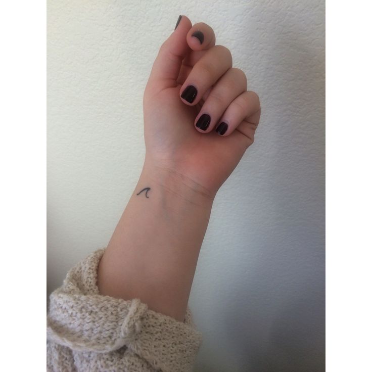 a woman's hand with a small tattoo on it