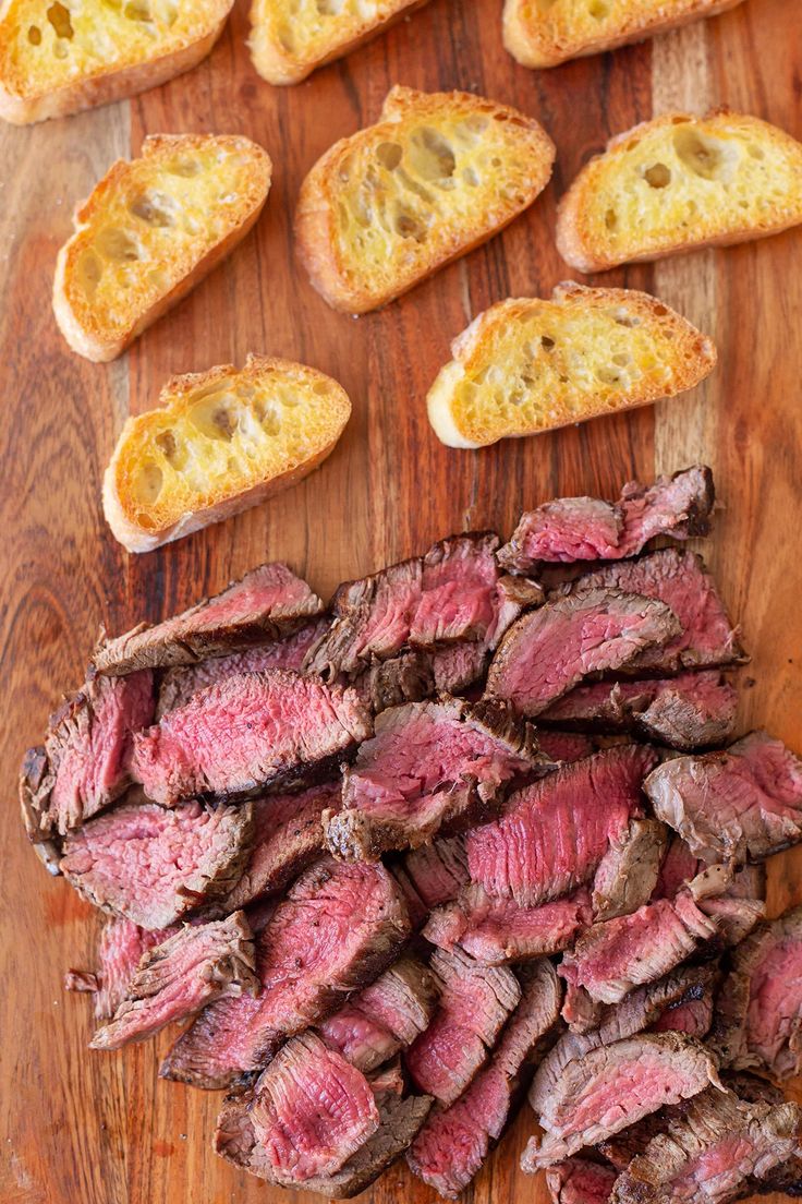 sliced steak and bread on a cutting board