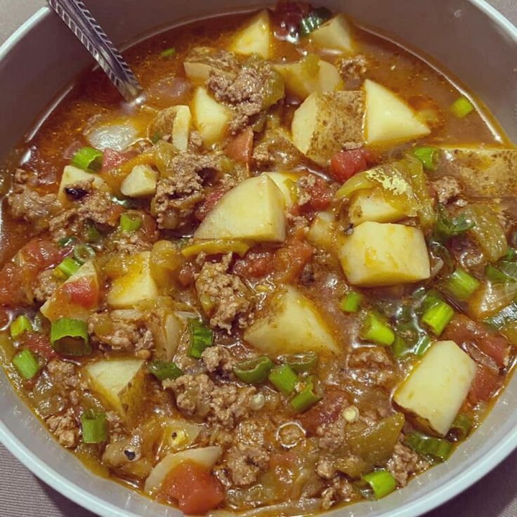 a white bowl filled with meat and vegetables