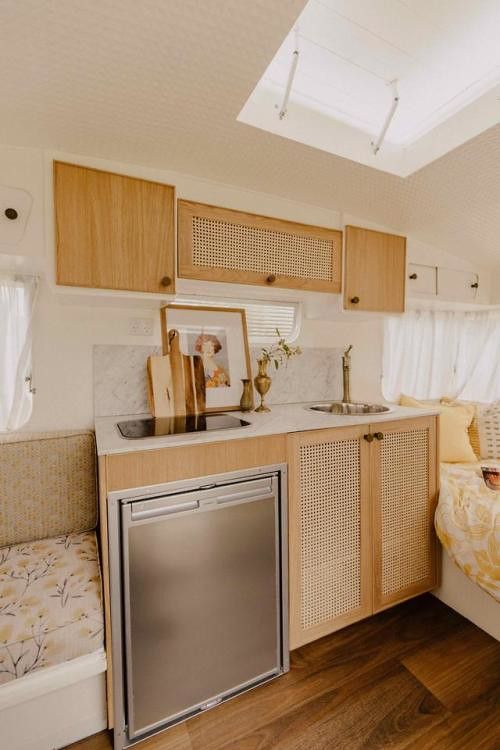 a kitchen with wooden cabinets and stainless steel dishwasher in the middle of it