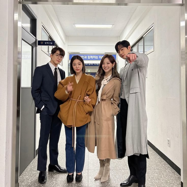 three people standing in an elevator posing for a photo with one pointing at the camera