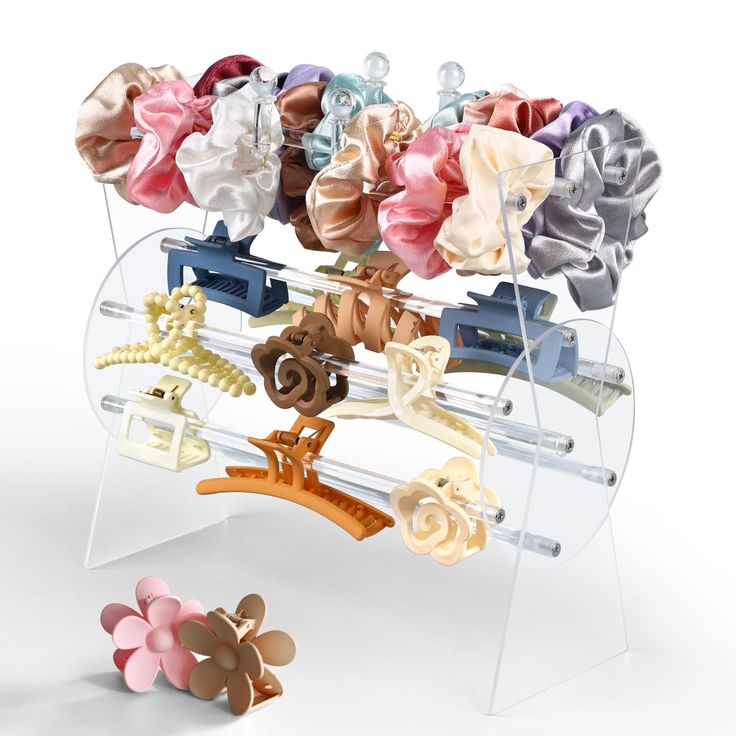 an assortment of hair clips on display in a clear case with acrylic stand