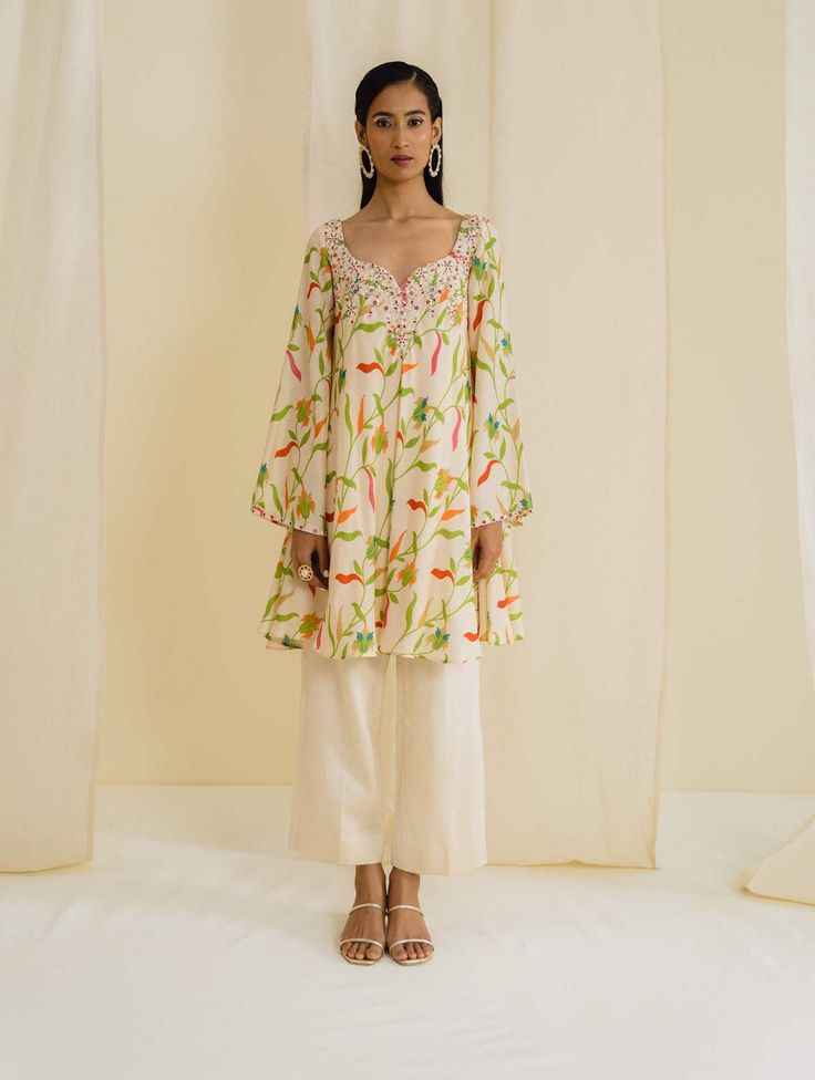 Editor's Note Featuring a cream kurta in dupion silk base with floral prints and bell sleeves. Paired with straight cropped pant. Fabric: Dupion silk, lining: crepe Color: Cream Neckline: Round with notch Sleeves: Full Fit: Relaxed Embroidery details: Hand embroidery Component: Kurta and pant Occasion: Daywear Care: Dry Clean Only About the Designer Drishti & Zahabia is all about contemporary styles and clean cuts with an Indian touch. Keeping it Elegant yet stylish and edgy, this designer duo a Kurta Styling, Sleeves Design For Kurtis, Fashion Study, Kurti Design, Dupion Silk, Study Style, Embroidery Details, Kurti Designs, Fashion Outfit