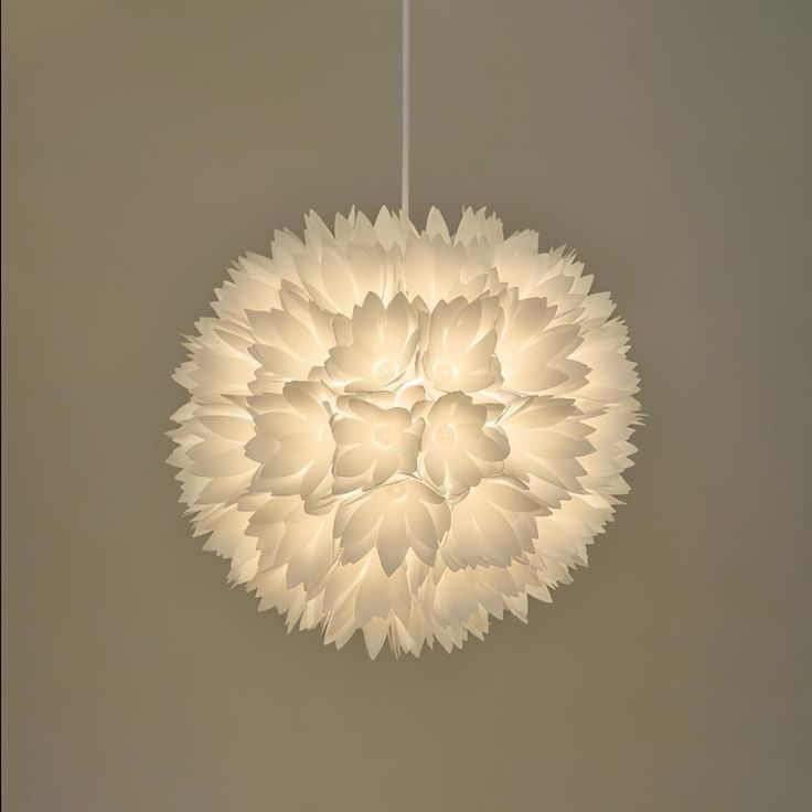 a white flower shaped light hanging from a ceiling