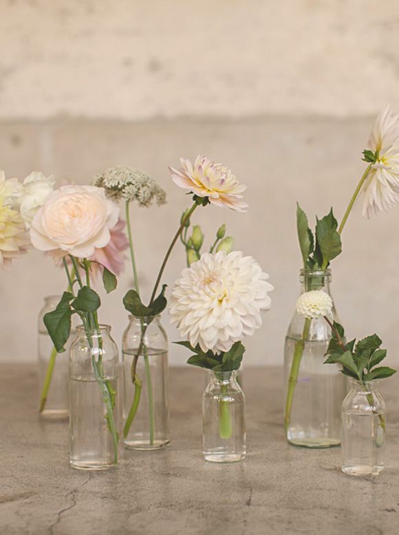 several vases with flowers in them sitting on a table