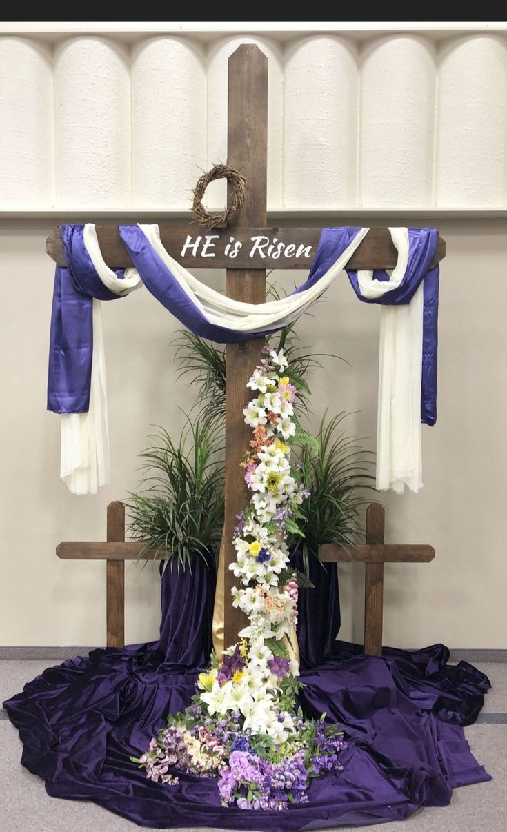 a cross decorated with flowers and ribbons