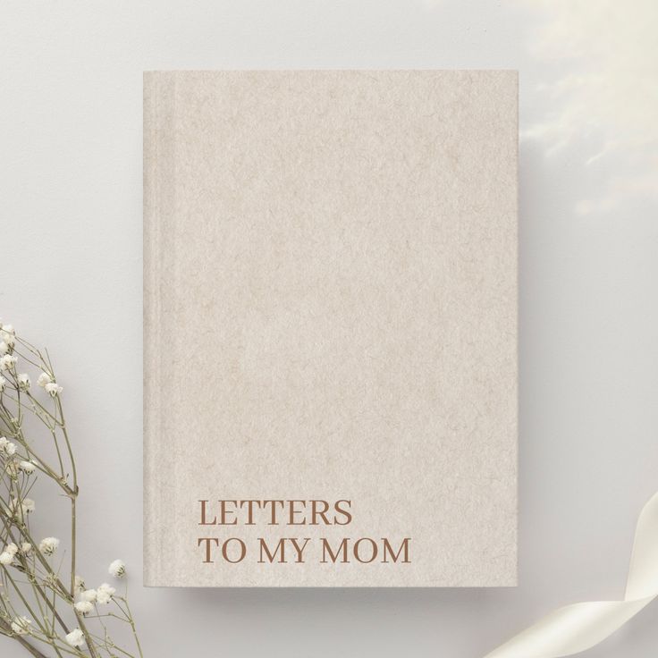 a book with the words letters to my mom written on it next to some baby's breath flowers