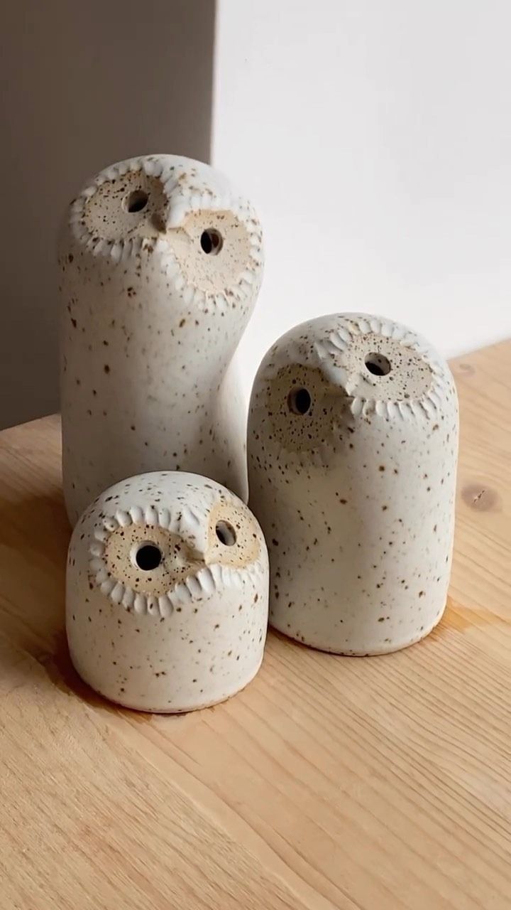 three ceramic owls sitting on top of a wooden table