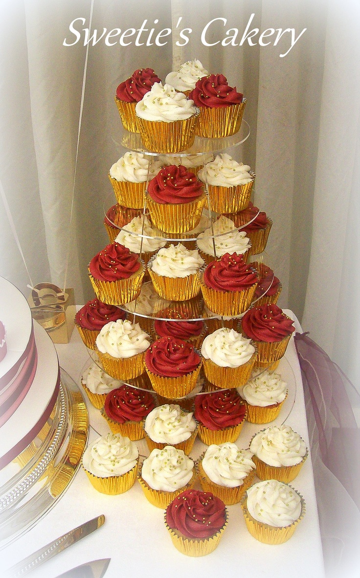 a tower of cupcakes with red and white frosting