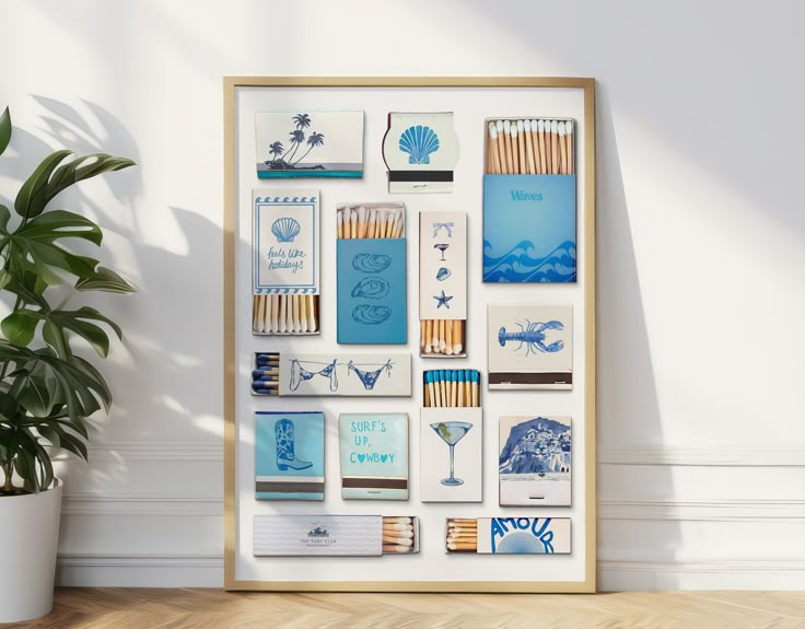 an art piece with various items on it in a wooden frame next to a potted plant