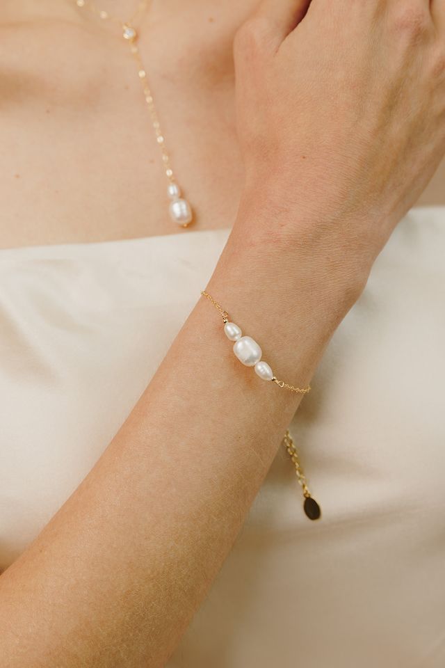 Introducing our Cosette Pearl Bracelet, a delicate and elegant piece of jewelry that is perfect for weddings or any formal occasion. This dainty gold chain bracelet features beautiful freshwater pearls that are hand wire-wrapped with a 14k yellow gold-filled chain, creating a stunning and timeless look. FEATURES Material: 14k Gold Fill, Freshwater Pearls Dimensions: 6" with a 2" extender Delicate Gold Bracelet For Formal Occasions, Delicate Pearl Drop Bracelet For Formal Occasions, Formal Gold Bracelet With Delicate Chain, Dainty Wire Wrapped Wedding Jewelry, Delicate Pearl Chain Bracelet With Pearl Charm, Elegant 14k Gold Filled Delicate Chain Bracelet, Elegant Gold Chain Bracelet For Bridesmaid Gift, Elegant Pearl Bracelet With Delicate Adjustable Chain, Delicate Adjustable Gold Bracelet